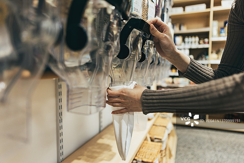 女士自带容器和购物袋在环保商店购物图片素材