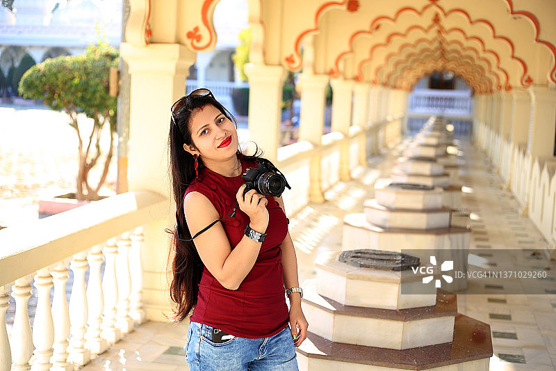 专业女摄影师使用单反相机拍照图片素材