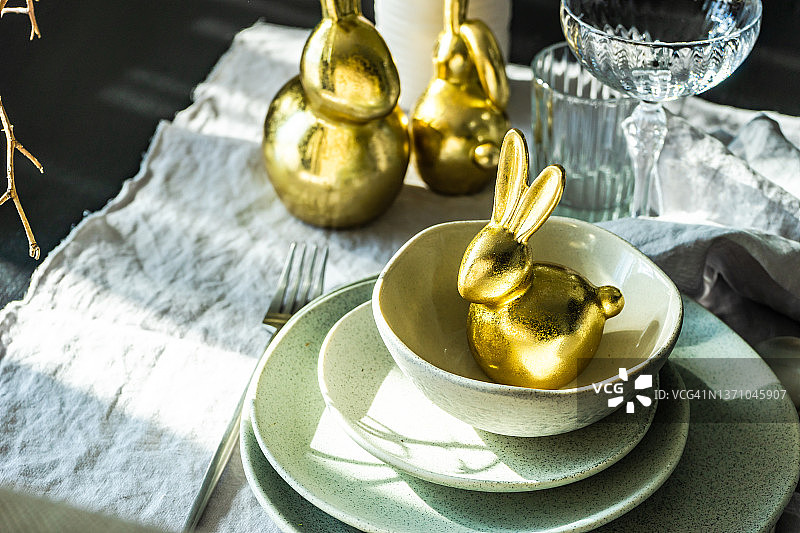 带有金色兔子装饰的节日复活节餐桌摆设图片素材