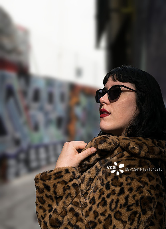 年轻女子身穿豹纹仿皮草外套和太阳镜的 портрет图片素材