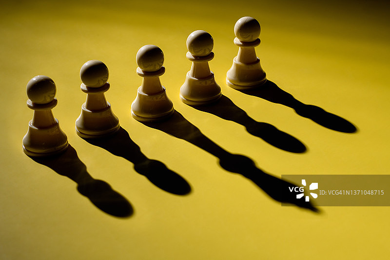 领导力概念：西洋棋子与高大阴影图片素材
