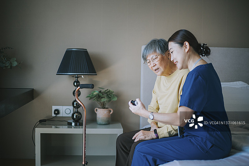 亚洲中国居家护理员教老年女人手腕锻炼进行物理治疗图片素材