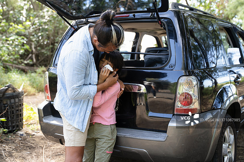 爸爸抱着在露营时受伤的女儿图片素材