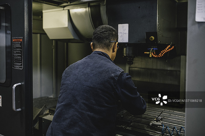 在工厂使用铣床的专业车床工人图片素材