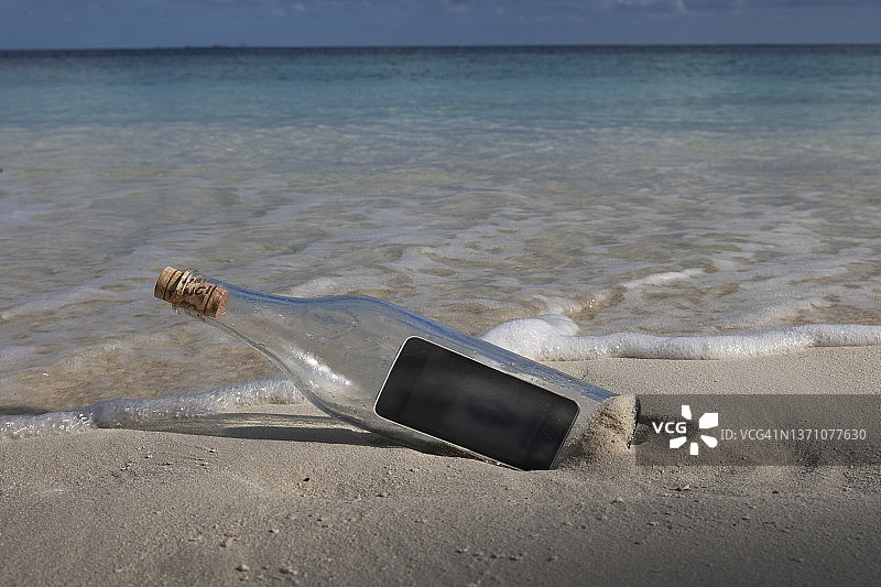 沙滩上的瓶中手机图片素材