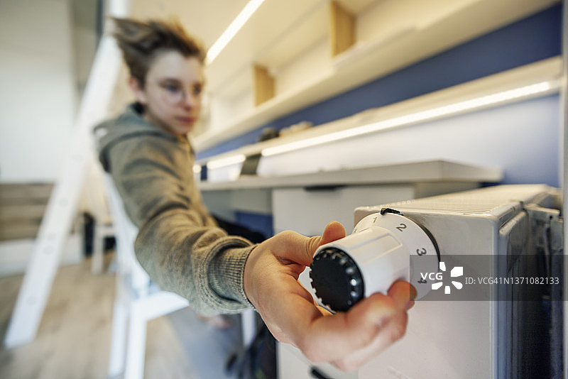 小男孩调低暖气图片素材