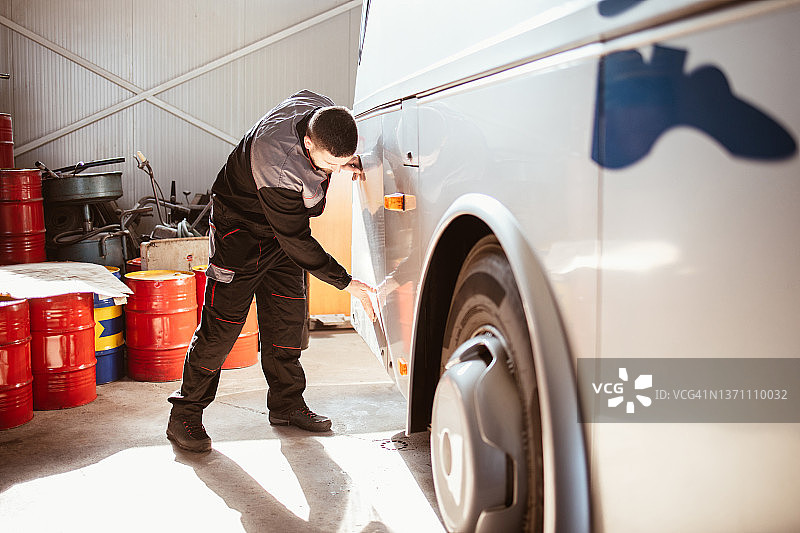 机械师在机械车间检查公共汽车图片素材