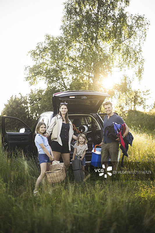 一家人在电动汽车充电站旁图片素材