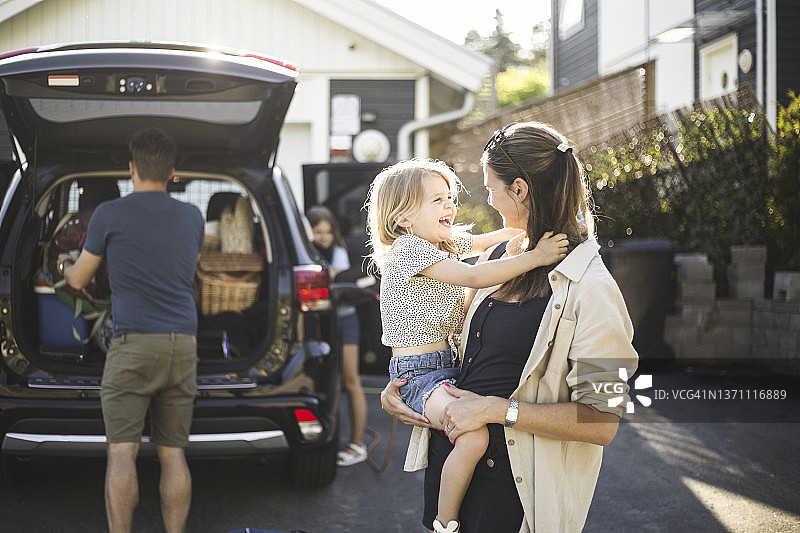 一家人在电动汽车充电站旁图片素材