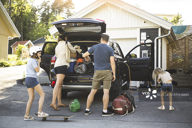 一家人在电动汽车充电站旁图片素材