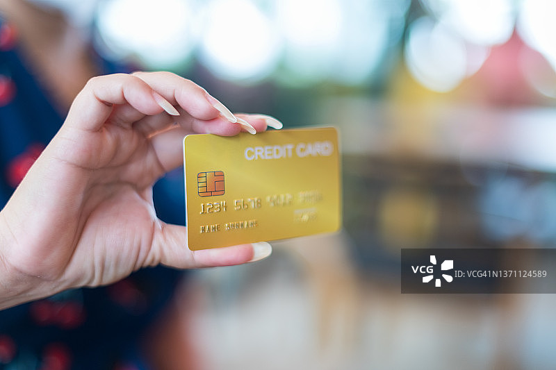 女人拿着信用卡进行在线支付图片素材