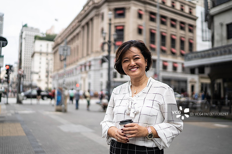 城市中的成熟亚洲女商人肖像图片素材