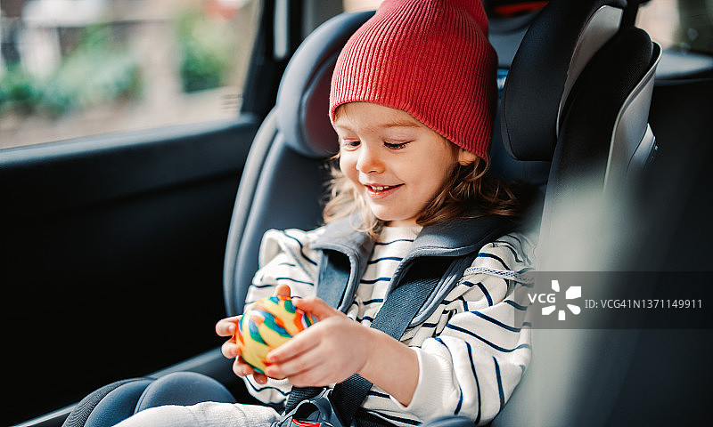 小女孩在车里拿着玩具图片素材