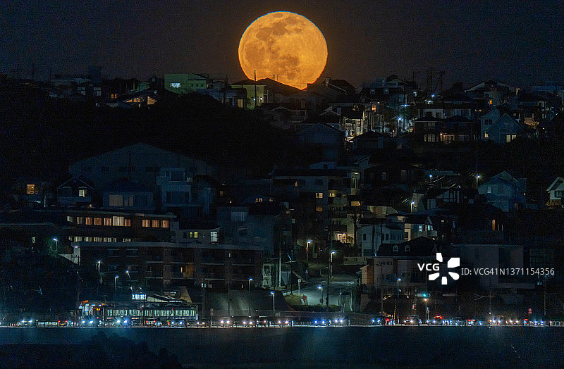日本神奈川县海边住宅区的血色满月图片素材