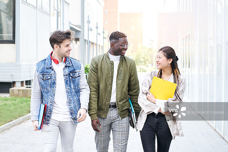 三名学生在大学校园里散步图片素材