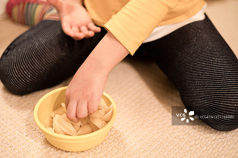 混血女孩在吃碗里的意大利面图片素材
