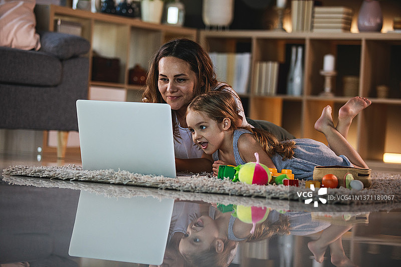 母女在地板上看卡通片图片素材