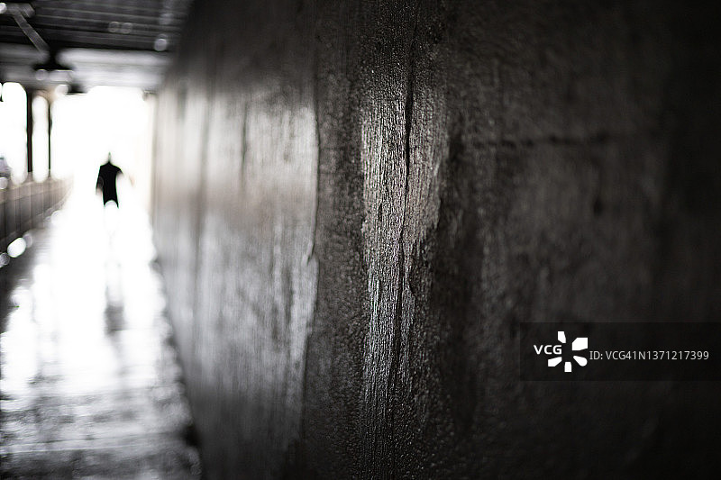 通勤火车站下的小镇人行通道，远处有难以辨认的人图片素材