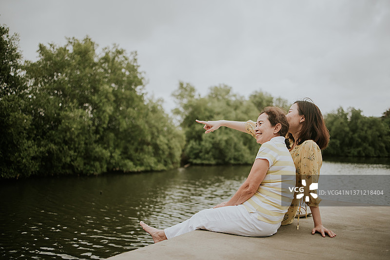 亚洲女儿指着一些生活在红树林中的鸟，让她的妈妈看图片素材