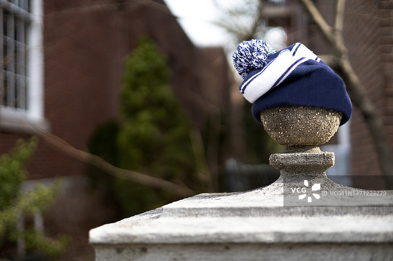街头摄影幽默：留在入口柱圆形顶饰上的绒球冬季无檐小便帽图片素材