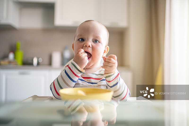 可爱小男孩在厨房用手吃饭图片素材