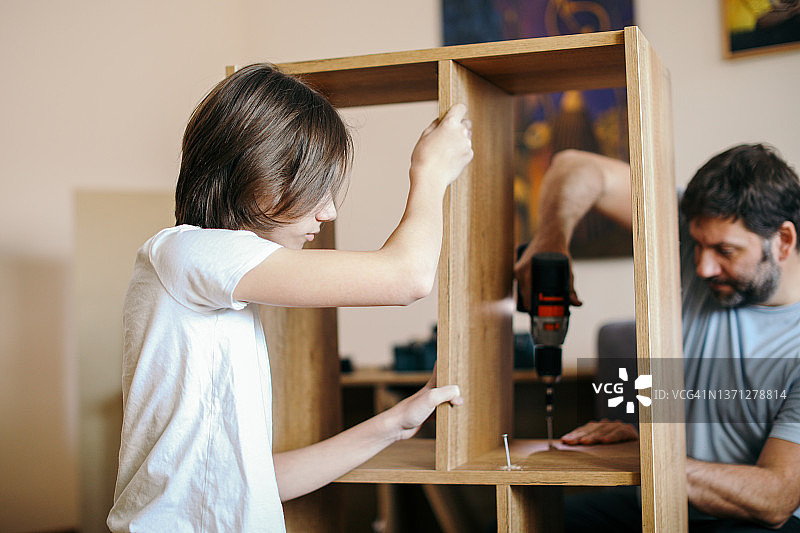 父子在家组装书架图片素材