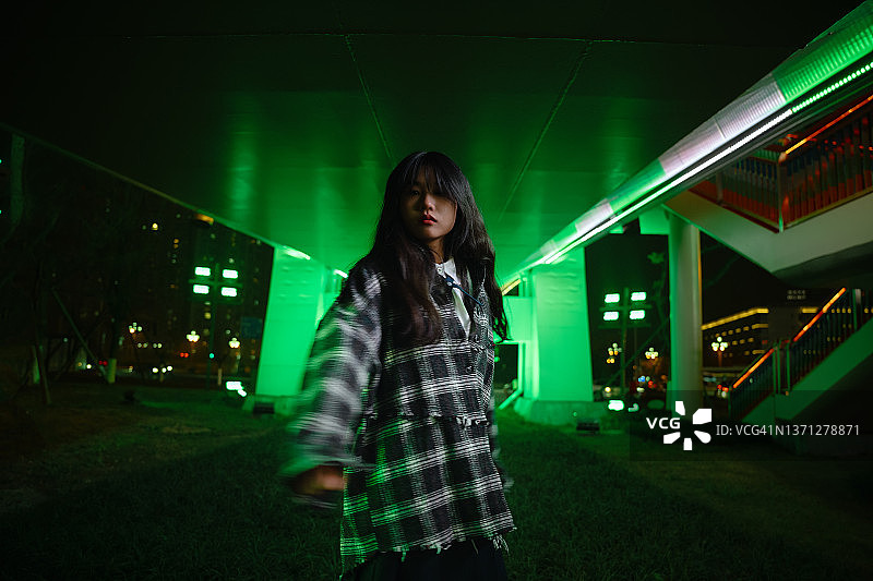 霓虹灯桥下的漂亮亚洲女孩图片素材