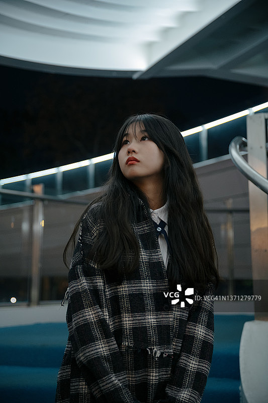 夜晚霓虹桥上的美丽亚洲女孩图片素材