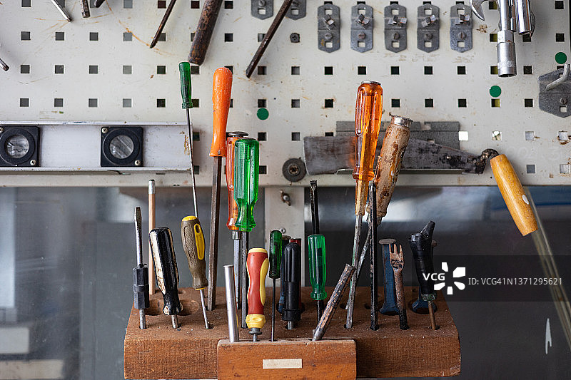 老式车间墙壁上的经典工具面板图片素材