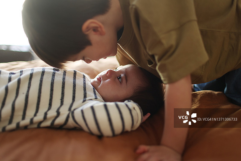 三岁男孩和他的弟弟在床上合影图片素材