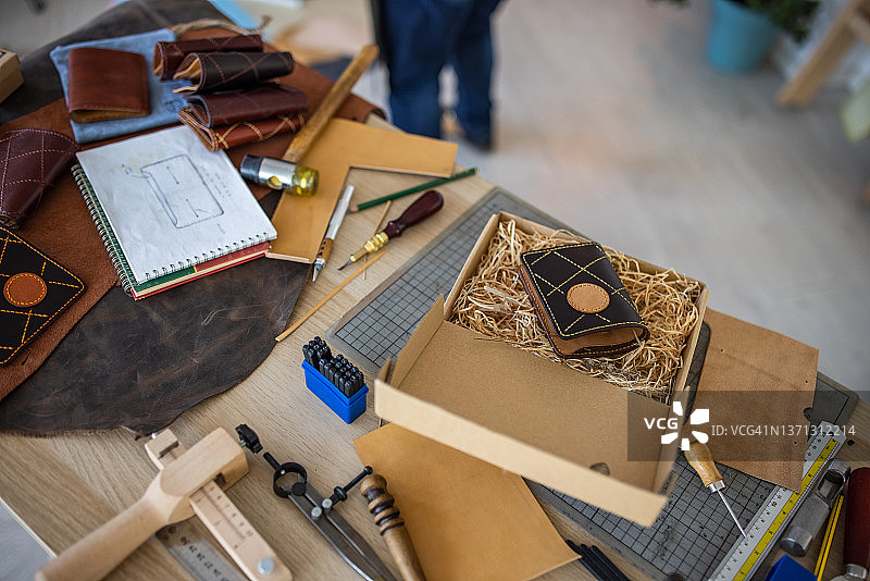 皮革匠包装她的新钱包并准备交付图片素材