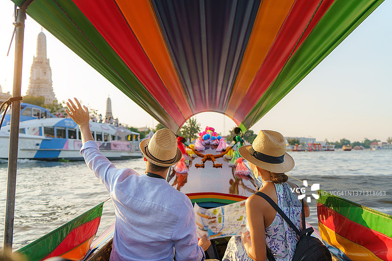 在泰国曼谷湄南河郑王庙观光的混血情侣，乘坐长尾船游览图片素材