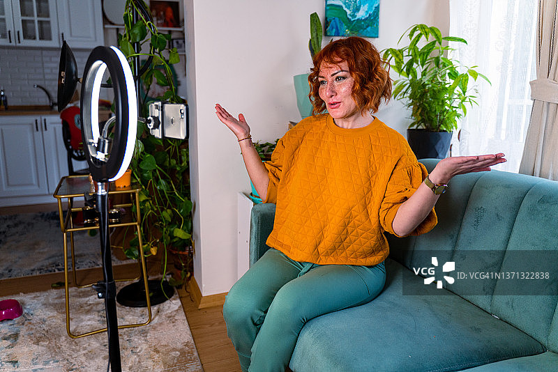 在客厅里发布Vlog的兴奋网红图片素材