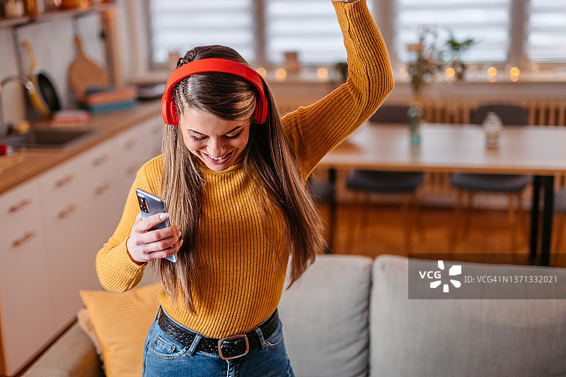 年轻女子在客厅里唱歌跳舞图片素材