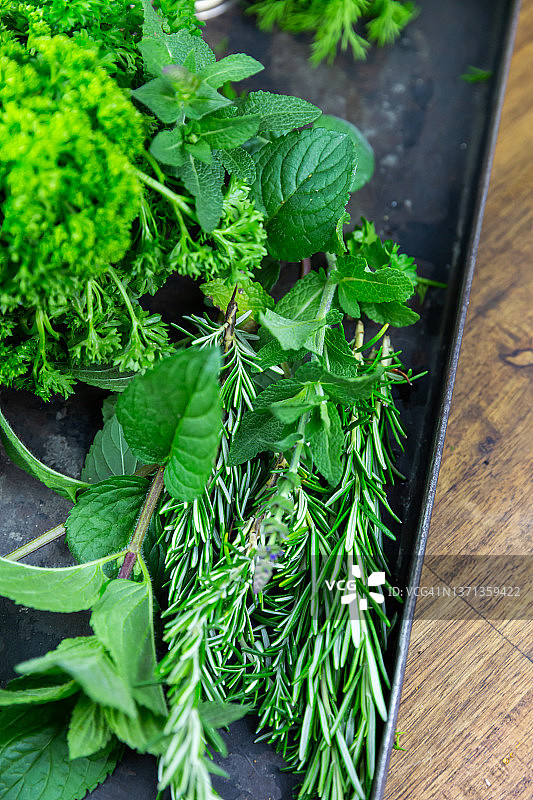 托盘上摆放的什锦新鲜绿色香草图片素材