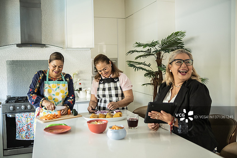 女性朋友在家用平板电脑准备墨西哥玉米粉蒸肉图片素材