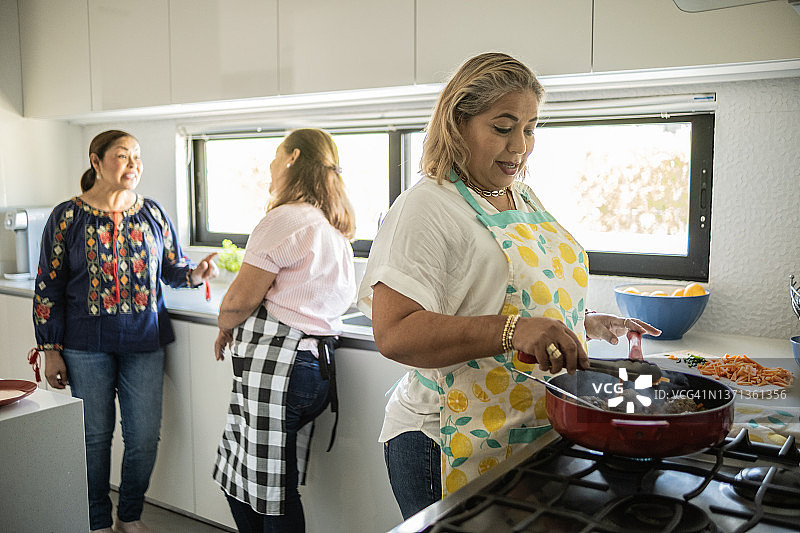 在家烹饪的拉丁裔中年妇女 - 准备墨西哥肉丸图片素材