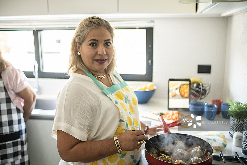在家烹饪墨西哥肉丸的中年拉丁裔妇女肖像图片素材