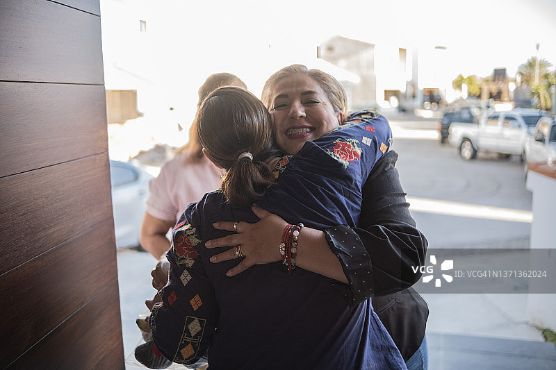 年长的拉丁女人在家欢迎朋友图片素材