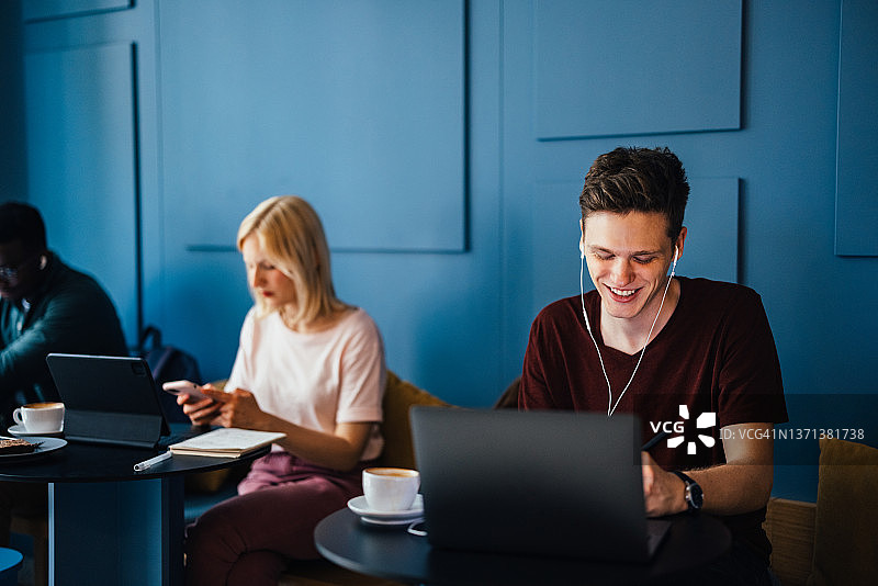 快乐的学生在咖啡店进行视频聊天图片素材