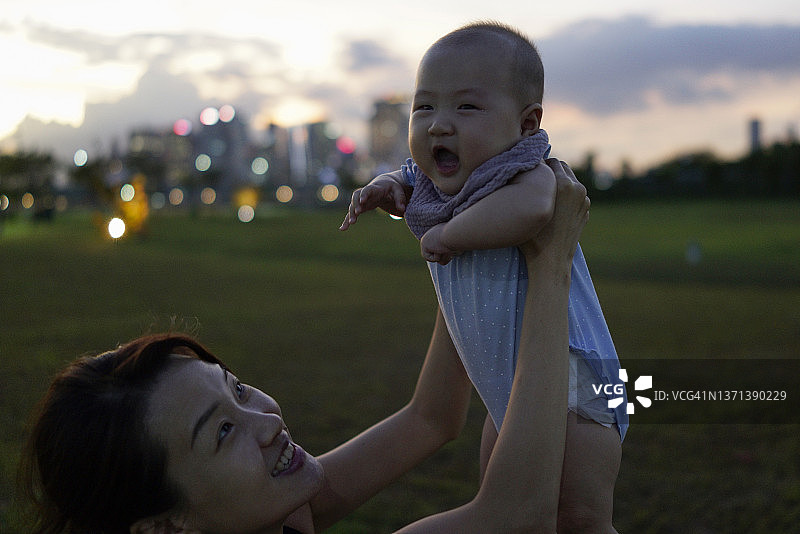 亚洲妈妈在黄昏时分与宝宝互动图片素材