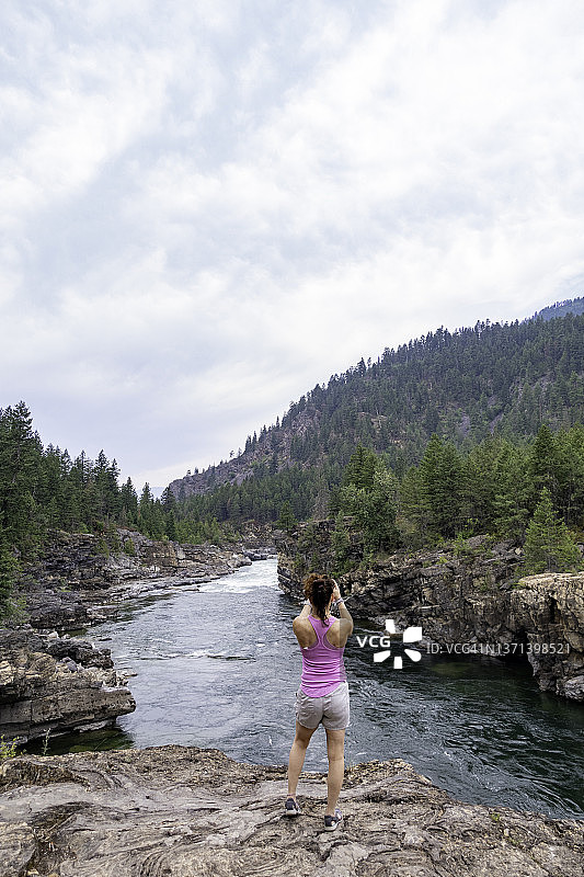 一位女士在蒙大拿州库特内瀑布观看河流图片素材