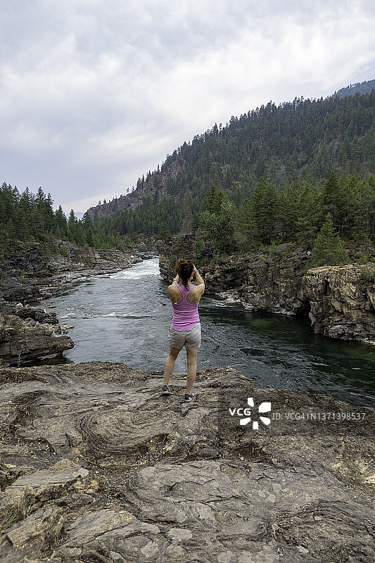 一位女士在蒙大拿州库特内瀑布观看河流图片素材