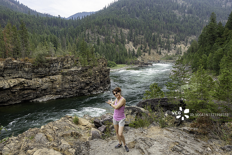 女人走过蒙大拿州库特奈瀑布。图片素材