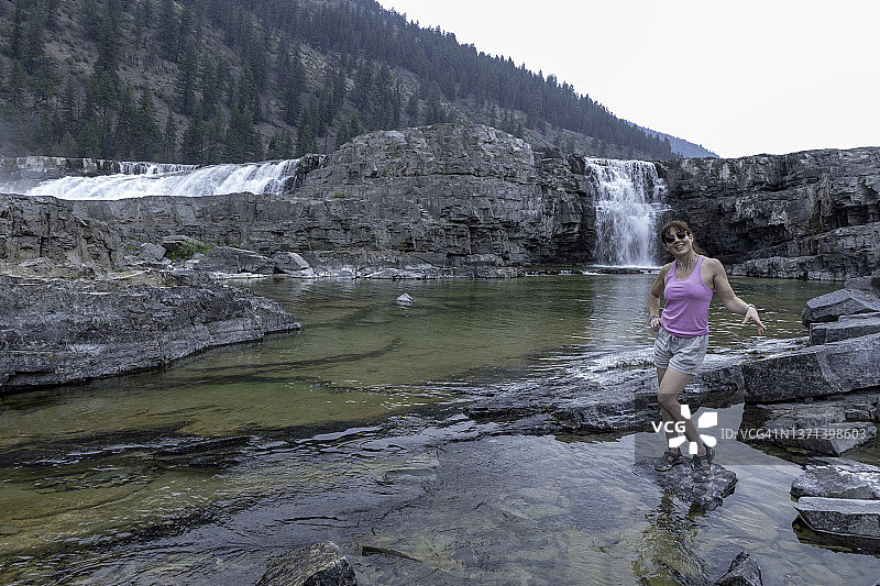 一位女士站在蒙大拿州库特奈瀑布旁图片素材