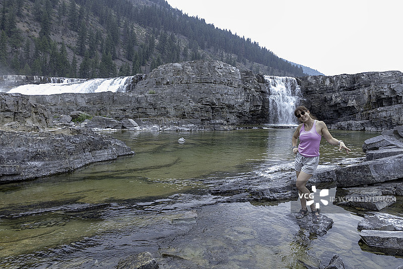 女人走过蒙大拿州库特奈瀑布。图片素材