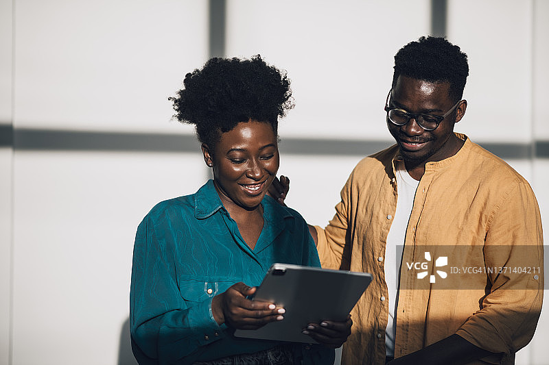 两位自信的年轻非裔美国同事在工作休息期间玩得开心图片素材