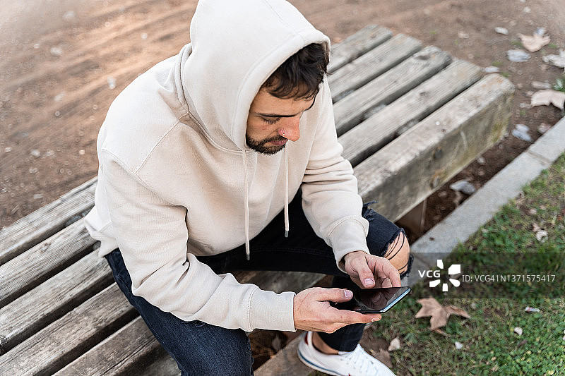 快乐地看着镜头的发短信的年轻男人图片素材
