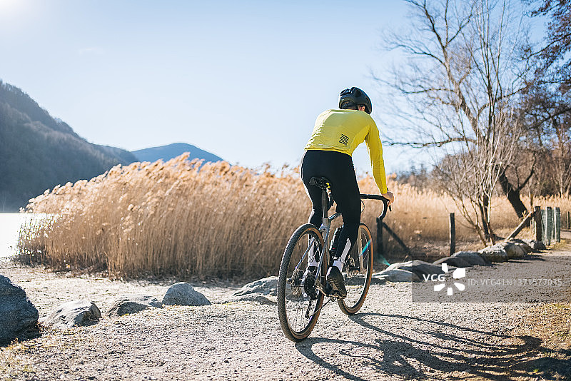 自行车手骑行经过卢加诺湖图片素材