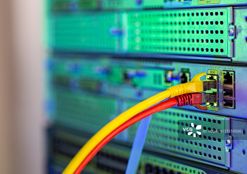 已插入的黄色和红色以太网线缆特写图片素材